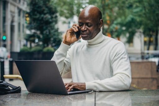 Businessman africain au téléphone et sur son ordinateur portable