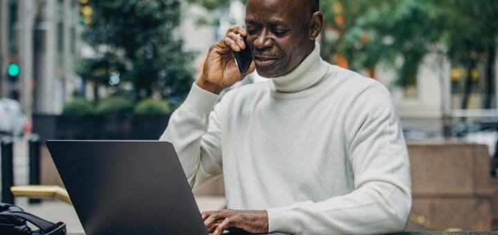 Businessman africain au téléphone et sur son ordinateur portable